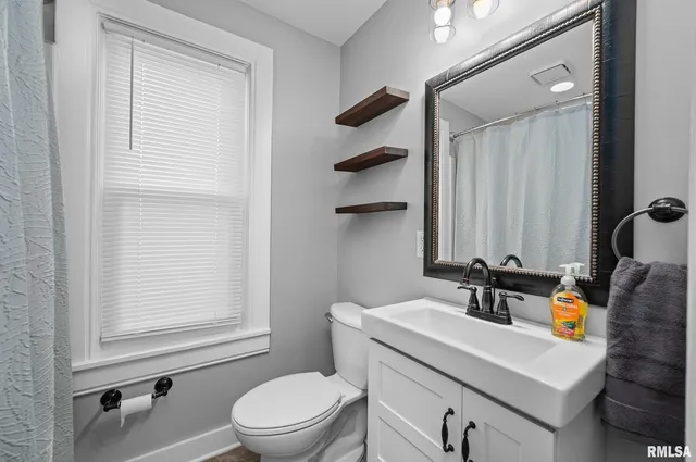 a bathroom with a sink a toilet and a mirror