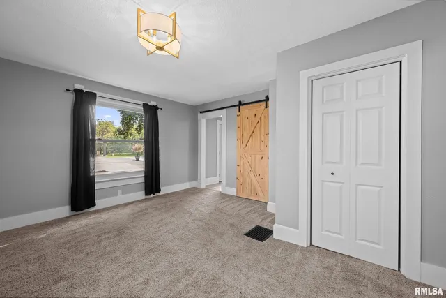 an empty room with windows and closet