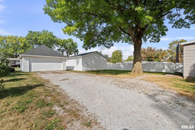 a front view of a house with a garden and tree