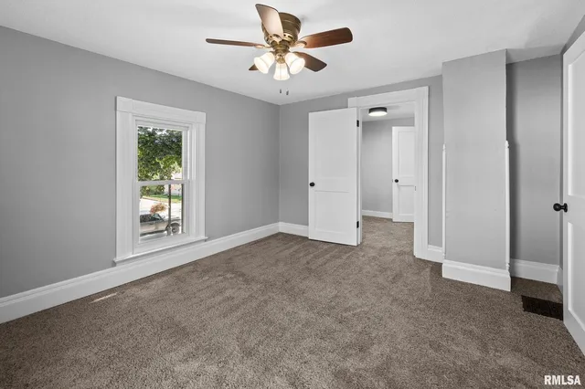 a view of a livingroom with a ceiling fan and window