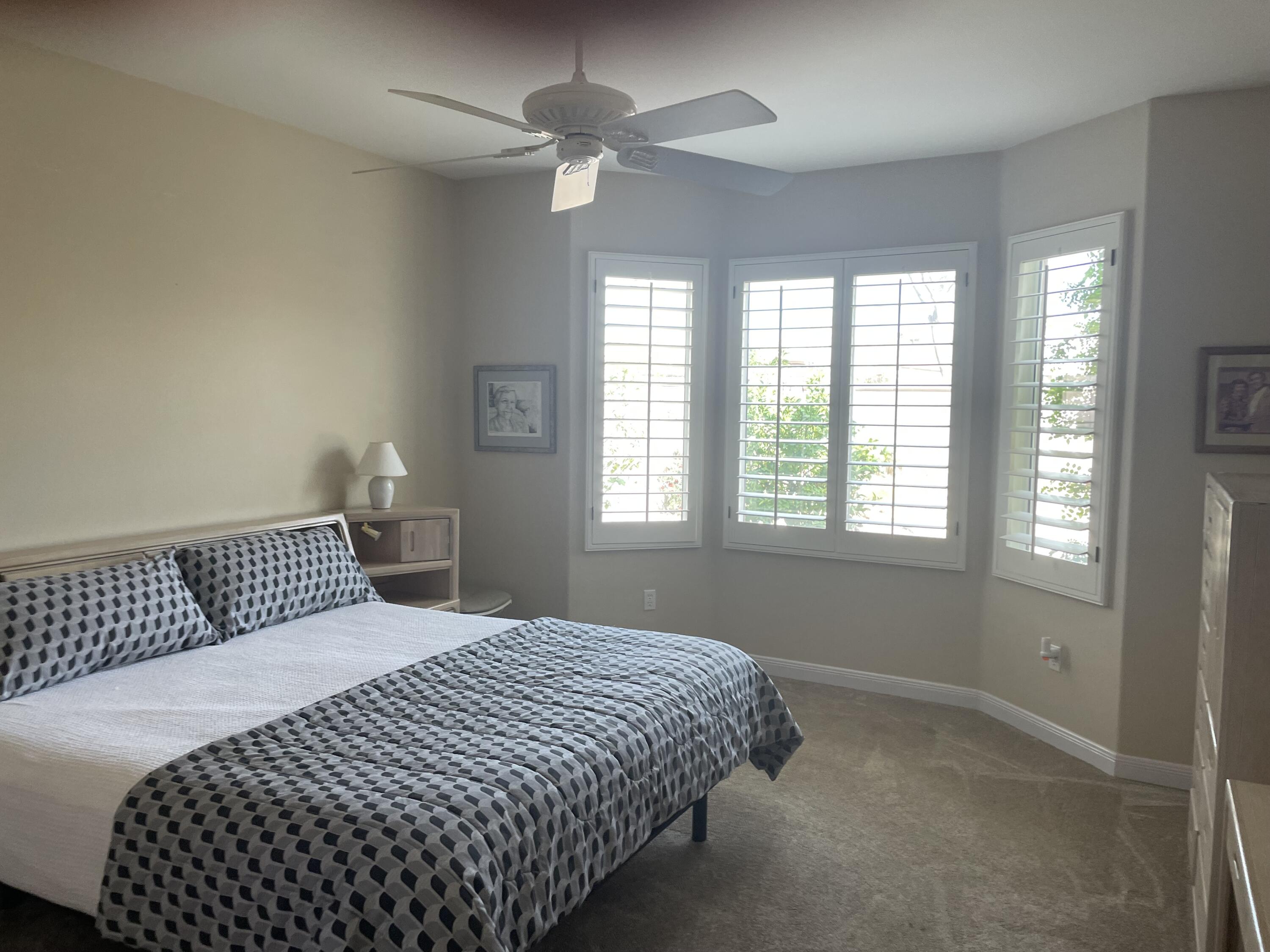 78212 Vinewood Drive Palm Desert, CA 92211 - Photo 11 of 15 a bedroom with a large bed and a window