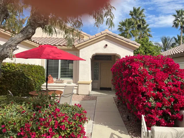 a view of a house with a yard and sitting area