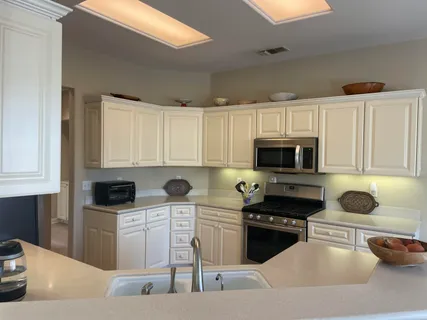 a kitchen with stainless steel appliances a stove a sink a microwave and cabinets