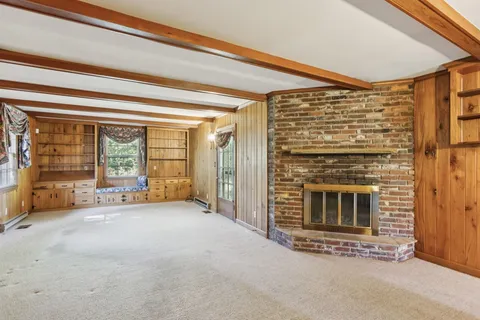 a view of an empty room with a fireplace and a window