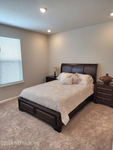 a large bed sitting in a room next to a window