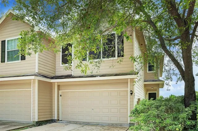 a yellow house with trees in front of it