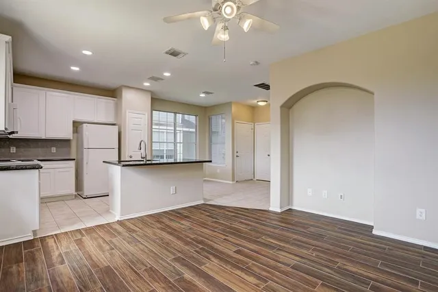 a view of kitchen with refrigerator and wooden floor