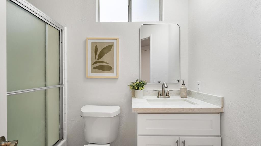 415 Stoney Point Way, Unit 106 Oceanside, CA 92058 - Photo 17 of 35 a bathroom with a toilet sink and mirror