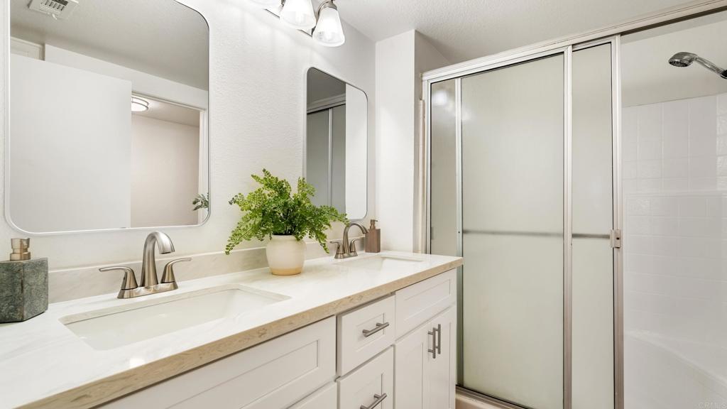 415 Stoney Point Way, Unit 106 Oceanside, CA 92058 - Photo 18 of 35 a bathroom with a shower sink and vanity