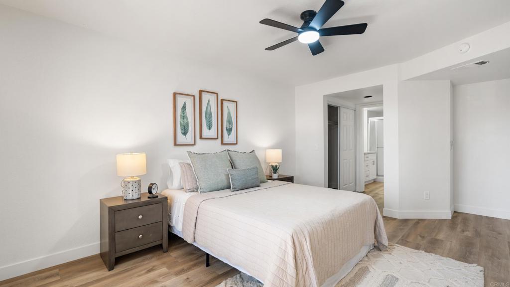 415 Stoney Point Way, Unit 106 Oceanside, CA 92058 - Photo 20 of 35 a bedroom with a bed and a lamp on the dresser