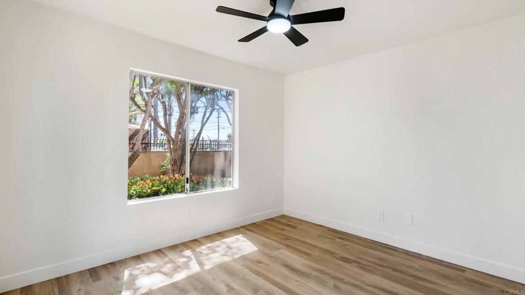 415 Stoney Point Way, Unit 106 Oceanside, CA 92058 - Photo 25 of 35 an empty room with wooden floor fan and windows