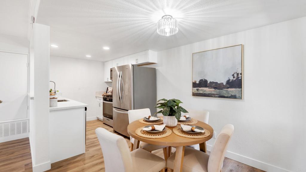 415 Stoney Point Way, Unit 106 Oceanside, CA 92058 - Photo 3 of 35 a view of a dining room with furniture and wooden floor