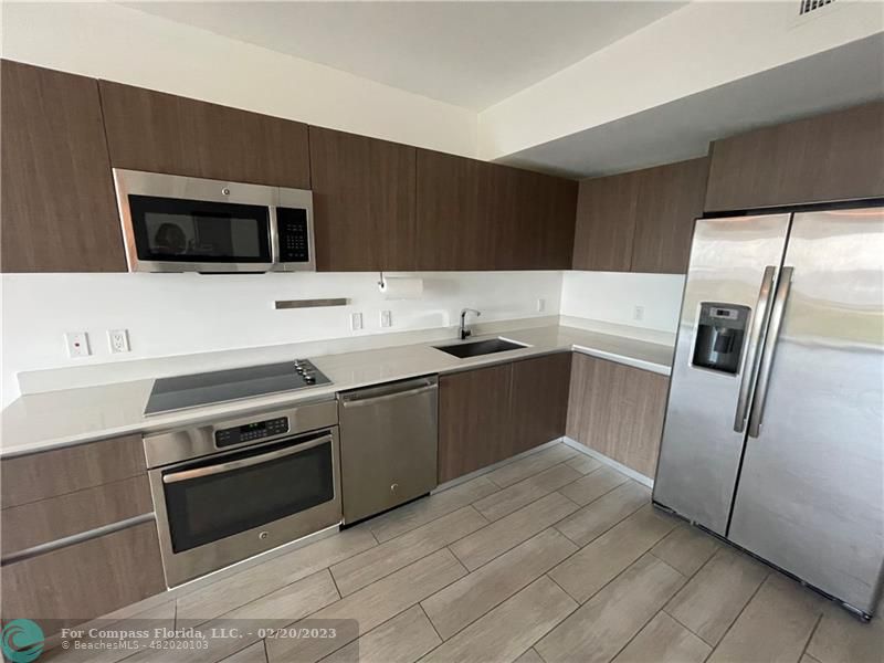 a kitchen with stainless steel appliances a stove a microwave and a sink