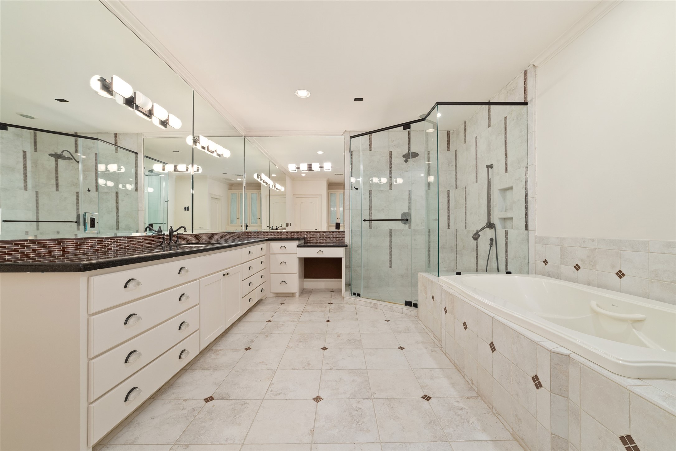 4102 Gramercy Street Houston, TX 77025 - Photo 21 of 35 a large bathroom with a double vanity sink a large mirror and shower
