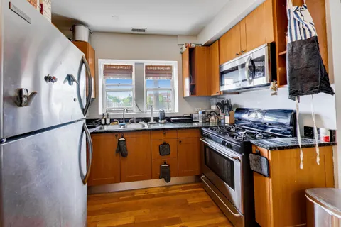 a kitchen with stainless steel appliances granite countertop a refrigerator a stove and a sink