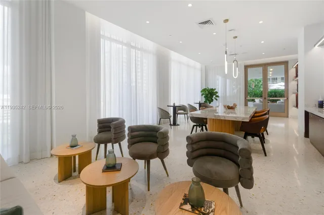 a living room with a table chairs and a flat screen tv