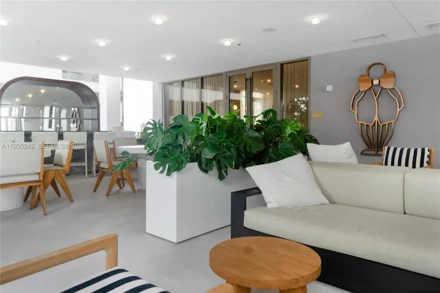 a living room with furniture a mirror and a large window