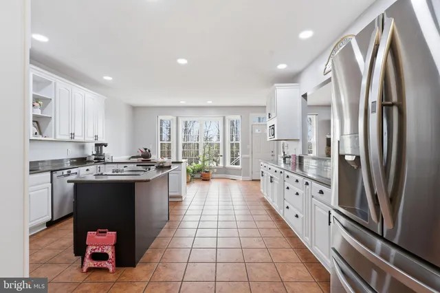 a kitchen with granite countertop a stove top oven microwave and cabinets