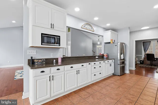 a kitchen with granite countertop white cabinets and sink