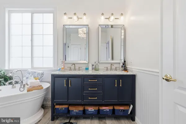 a bathroom with a tub shower sink and mirror