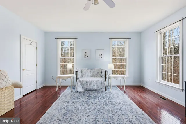 a living room with furniture wooden floor and a window