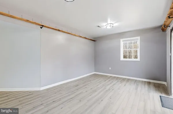 an empty room with windows and fan