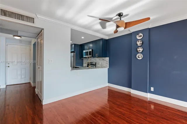 a view of a kitchen with wooden floor and a ceiling fan