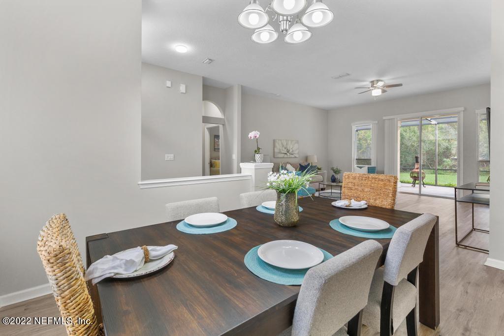 1229 Paradise Pond Road St. Augustine, FL 32092 - Photo 11 of 23 a view of a dining room with furniture a chandelier and wooden floor