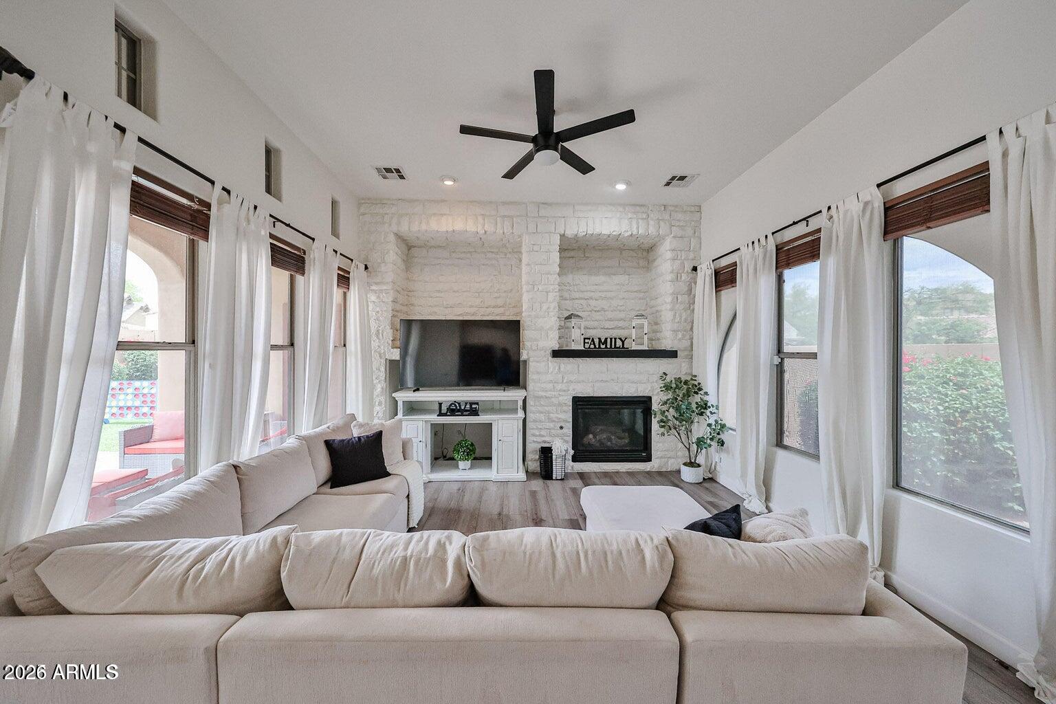 3950 North Edith Way Buckeye, AZ 85396 - Photo 15 of 32 a living room with furniture a fireplace and a flat screen tv