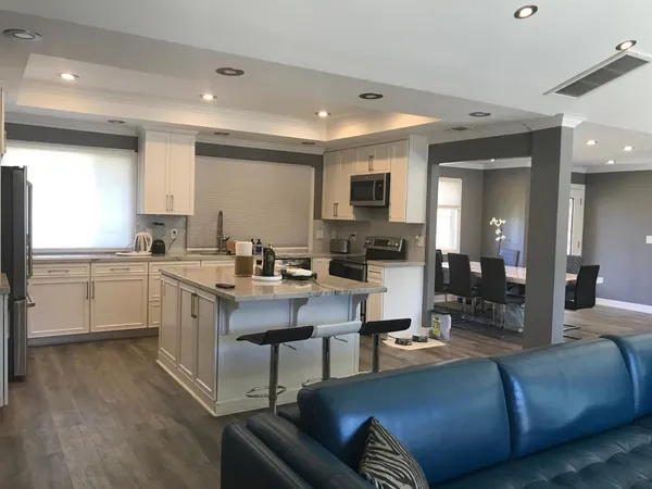 a living room with furniture kitchen and a chandelier