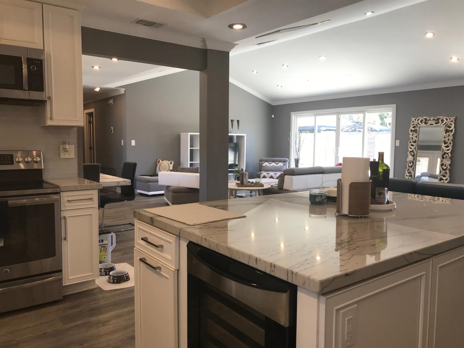 4448 Hackberry Lane Carmichael, CA 95608 - Photo 25 of 64 a kitchen with center island a sink dishwasher a stove and a dining table with wooden floor