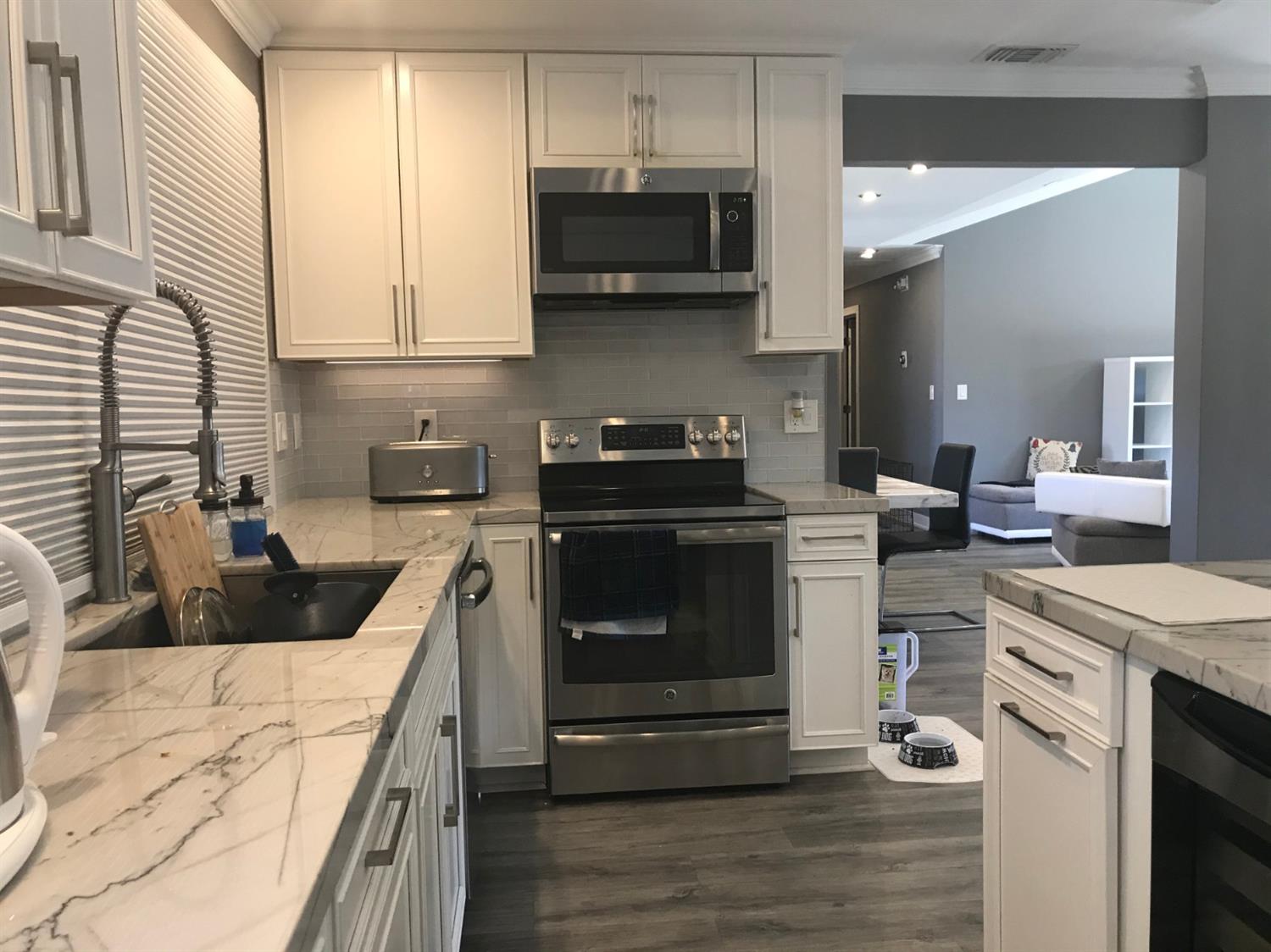 4448 Hackberry Lane Carmichael, CA 95608 - Photo 28 of 64 a kitchen with stainless steel appliances a stove a sink a microwave a refrigerator and cabinets