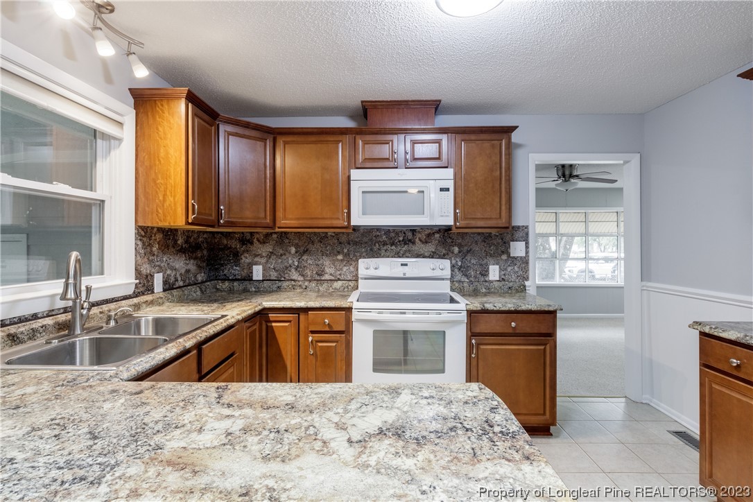 1412 Milton Street Spring Lake, NC 28390 - Photo 12 of 27 a kitchen with stainless steel appliances granite countertop a sink stove and refrigerator