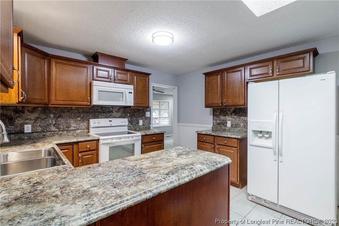 1412 Milton Street Spring Lake, NC 28390 - Photo 13 of 27 a kitchen with stainless steel appliances granite countertop a stove refrigerator sink and microwave