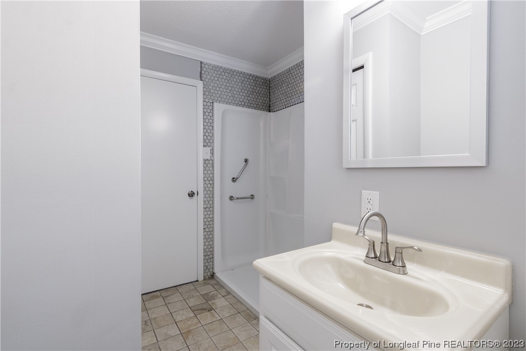 1412 Milton Street Spring Lake, NC 28390 - Photo 19 of 27 a bathroom with a sink and a mirror