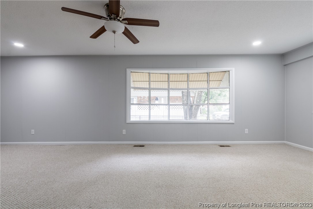 1412 Milton Street Spring Lake, NC 28390 - Photo 7 of 27 an empty room with chandelier fan and windows