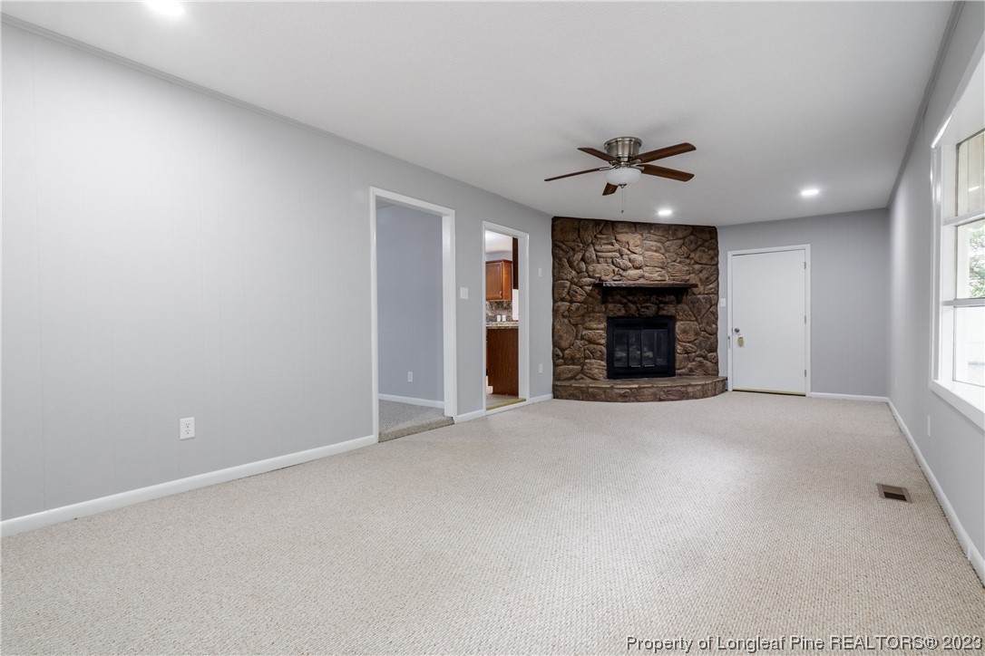 1412 Milton Street Spring Lake, NC 28390 - Photo 8 of 27 an empty room with fireplace and a ceiling fan