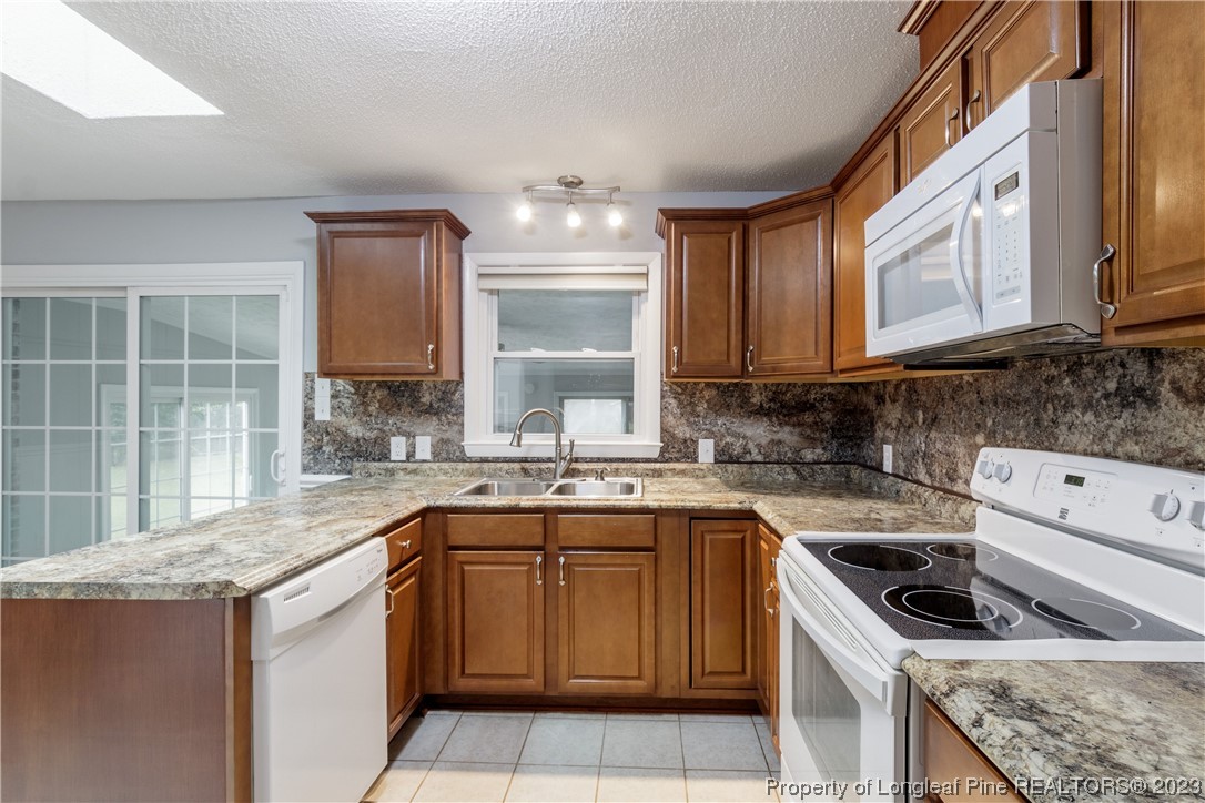 1412 Milton Street Spring Lake, NC 28390 - Photo 10 of 27 a kitchen with a sink stove top oven and cabinets