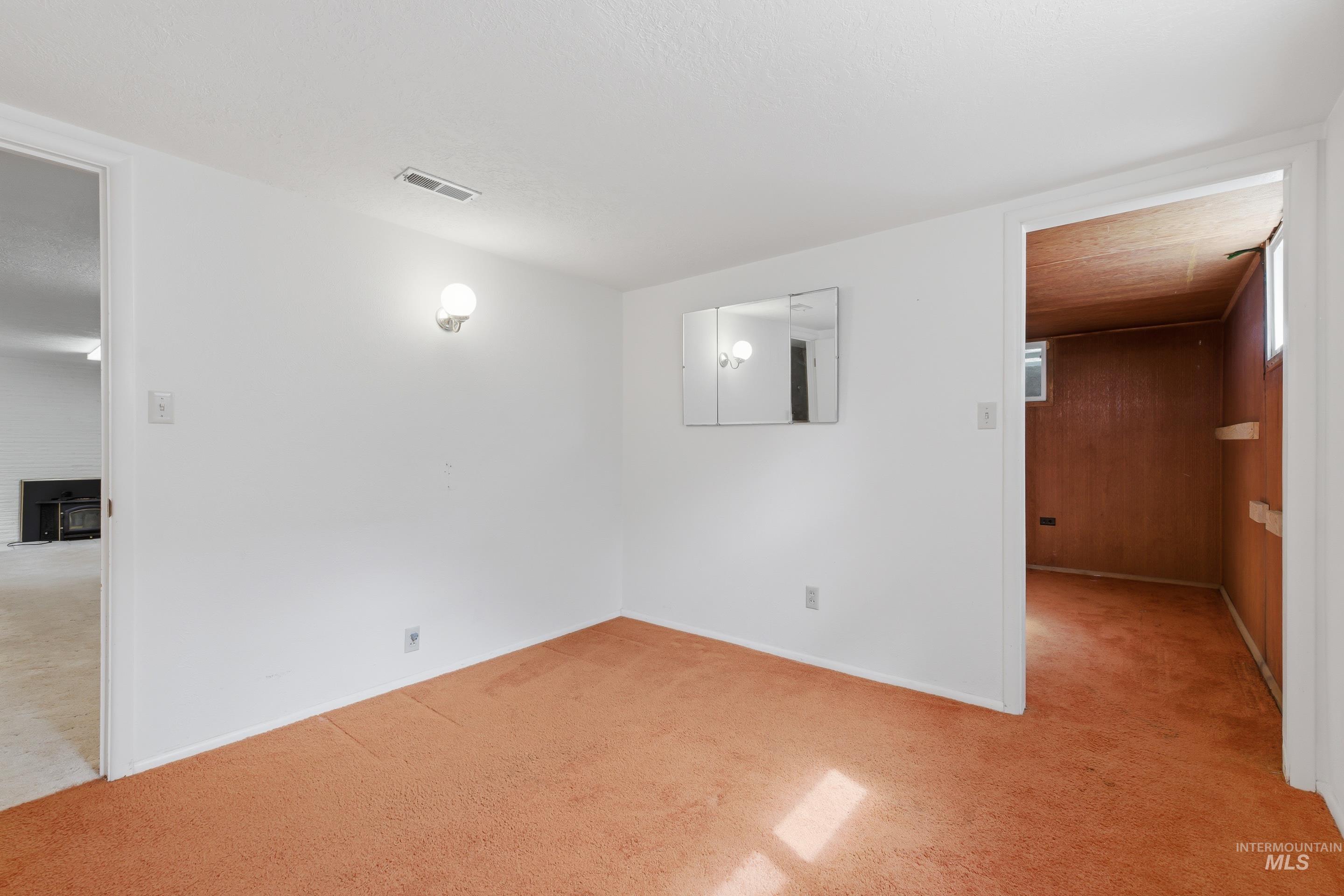 504 West Howe Street Boise, ID 83706 - Photo 30 of 47 Carpeted room with white walls, wall-mounted light fixture, and a tri-fold medicine cabinet