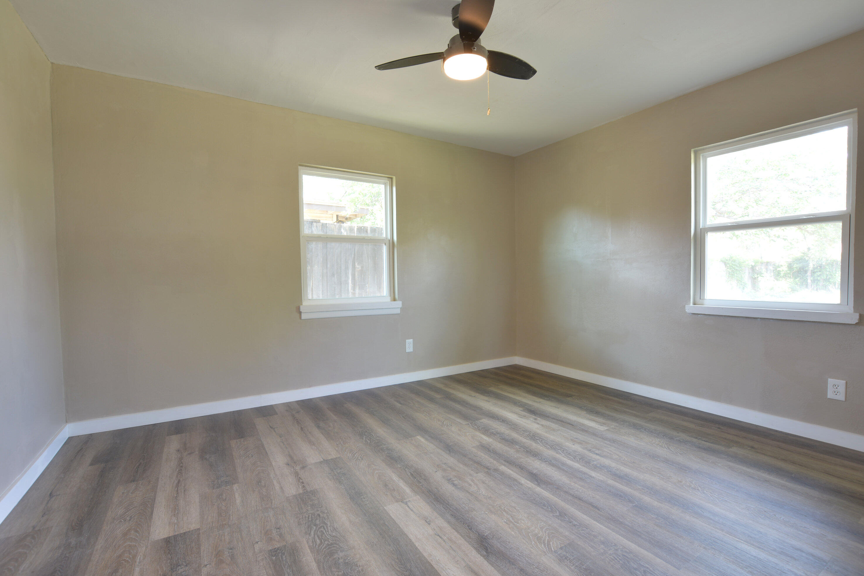 4608 Detroit Avenue Lubbock, TX 79413 - Photo 16 of 20 a view of empty room with wooden floor and fan