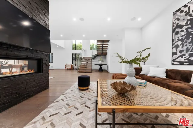 a living room with furniture a fireplace and wooden floor