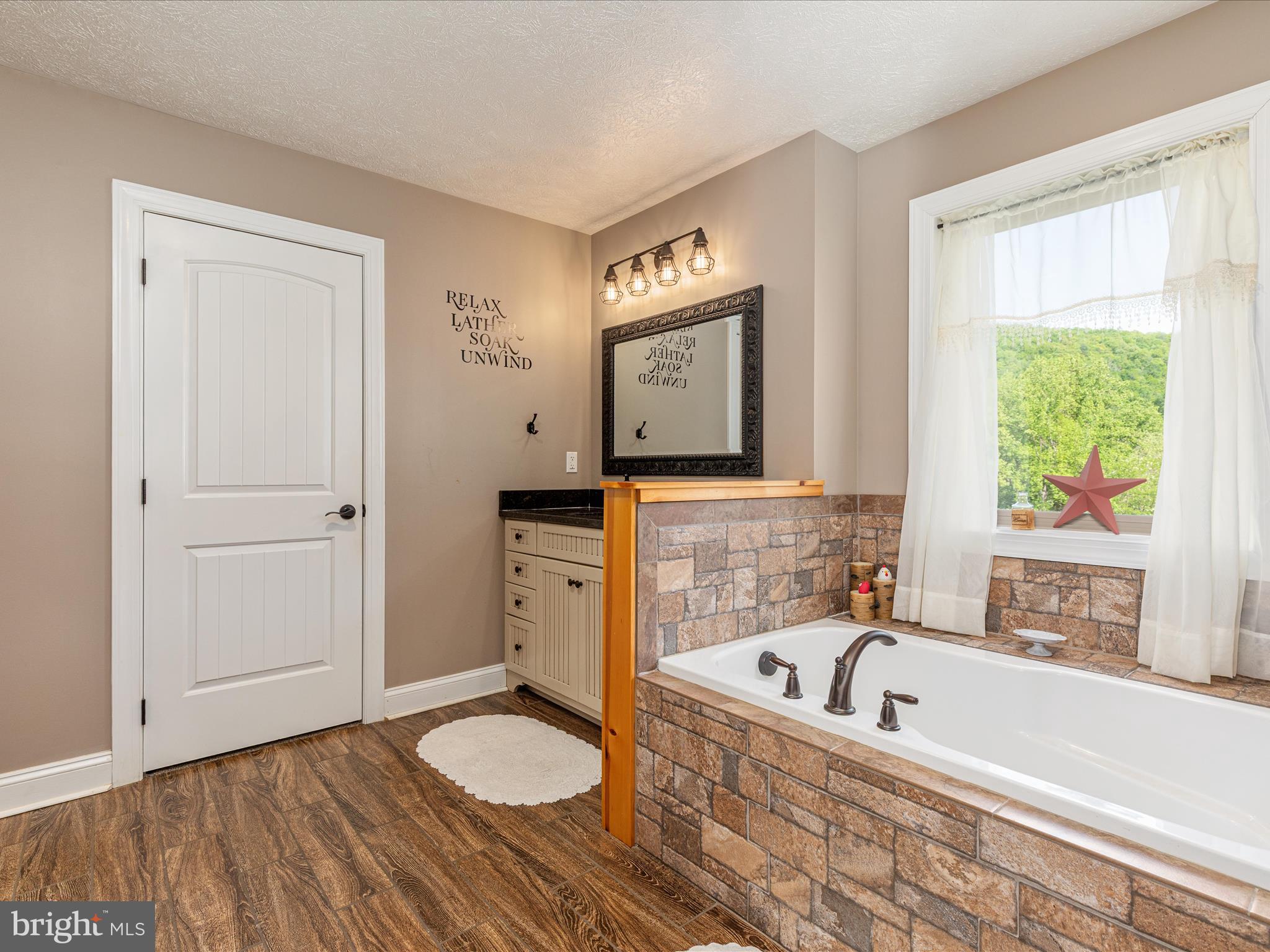 1996 Buck Mountain Road Bentonville, VA 22610 - Photo 28 of 61 a bathroom with a granite countertop sink and a bathtub