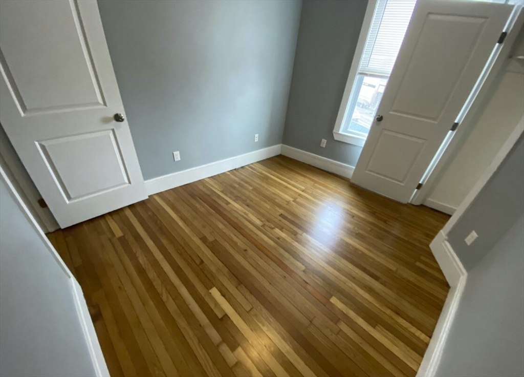 301 Hancock Street, Unit 2 Boston, MA 02125 - Photo 6 of 11 a view of empty room with wooden floor
