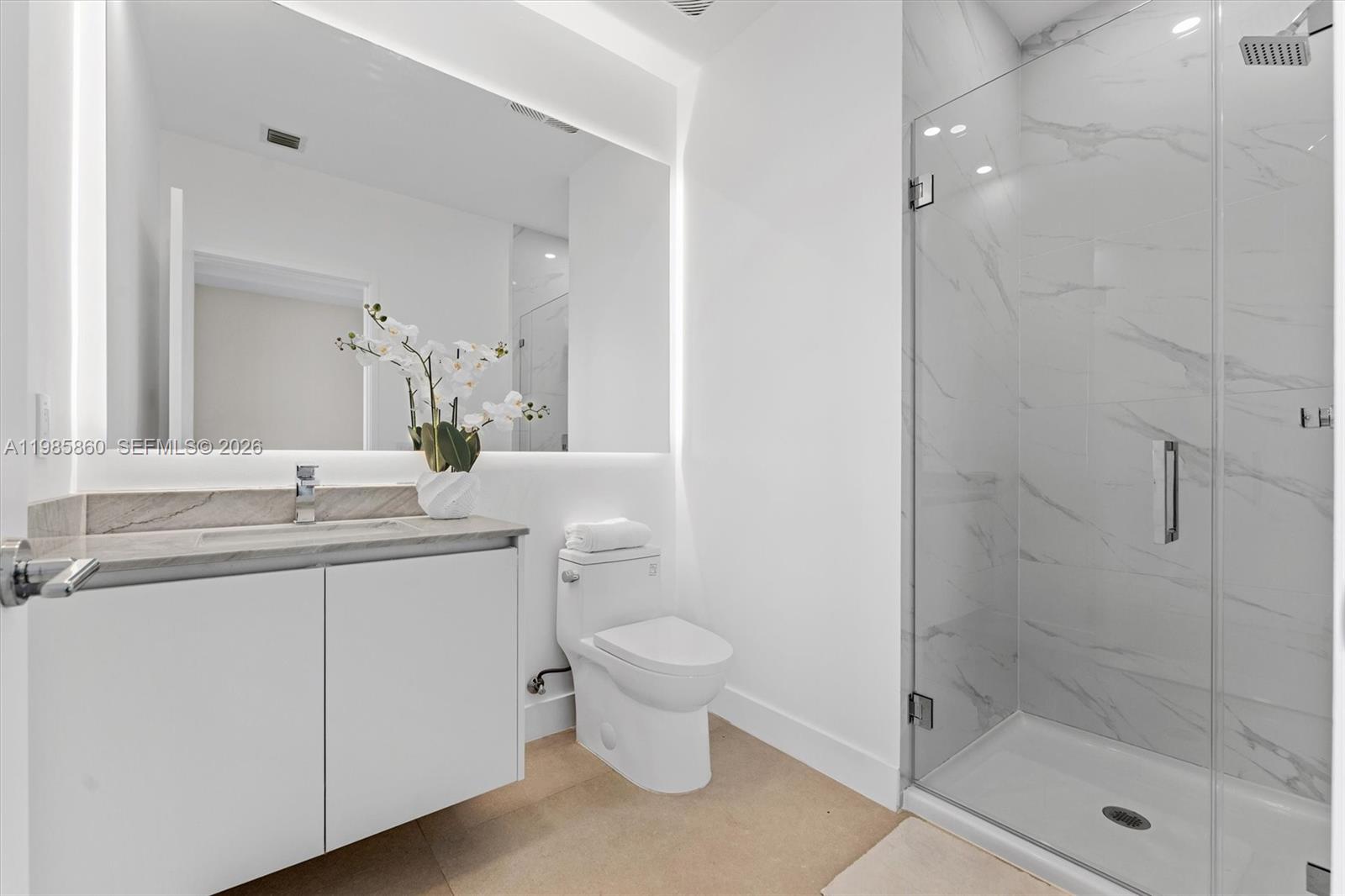 700 Northeast 24th Street, Unit PH5802 Miami, FL 33137 - Photo 22 of 59 a bathroom with a granite countertop toilet a sink and a mirror