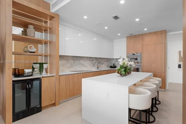 a large kitchen with stainless steel appliances a sink stove and cabinets