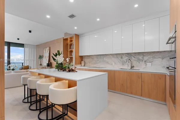 a kitchen with granite countertop white cabinets and stainless steel appliances