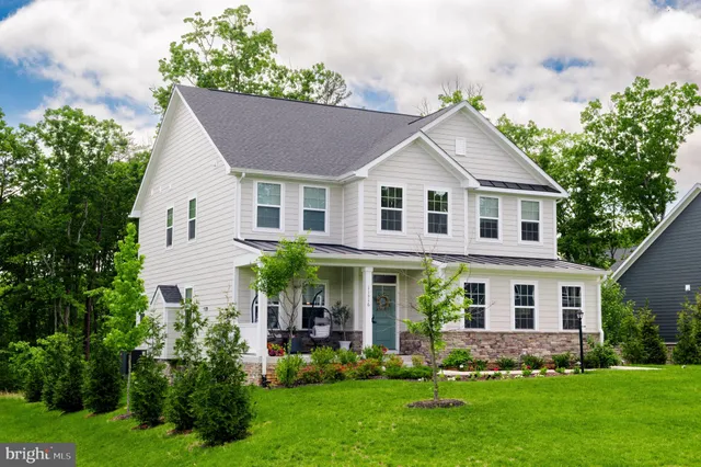 a front view of a house with a yard and trees