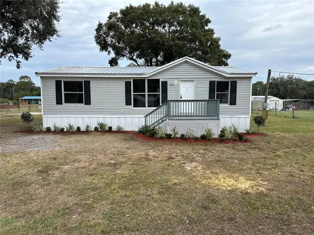 a white house covered with tall trees