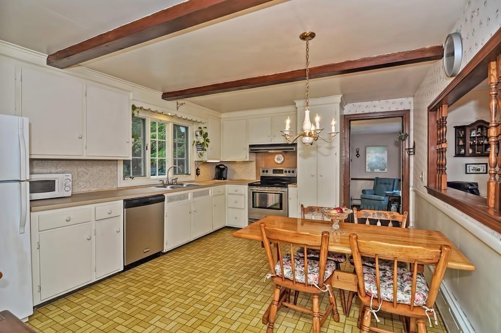 7 Rosedale Drive Bristol, RI 02809 - Photo 20 of 23 a kitchen with a dining table chairs cabinets and stainless steel appliances
