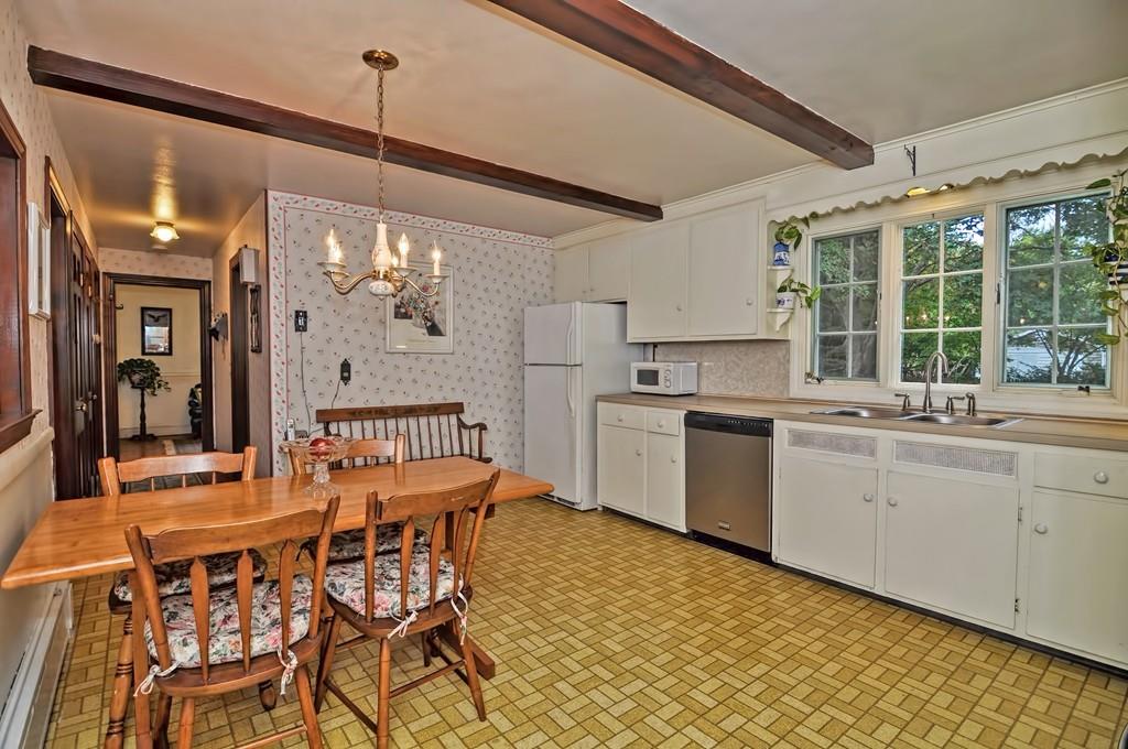 7 Rosedale Drive Bristol, RI 02809 - Photo 3 of 23 a kitchen with a dining table chairs sink and cabinets